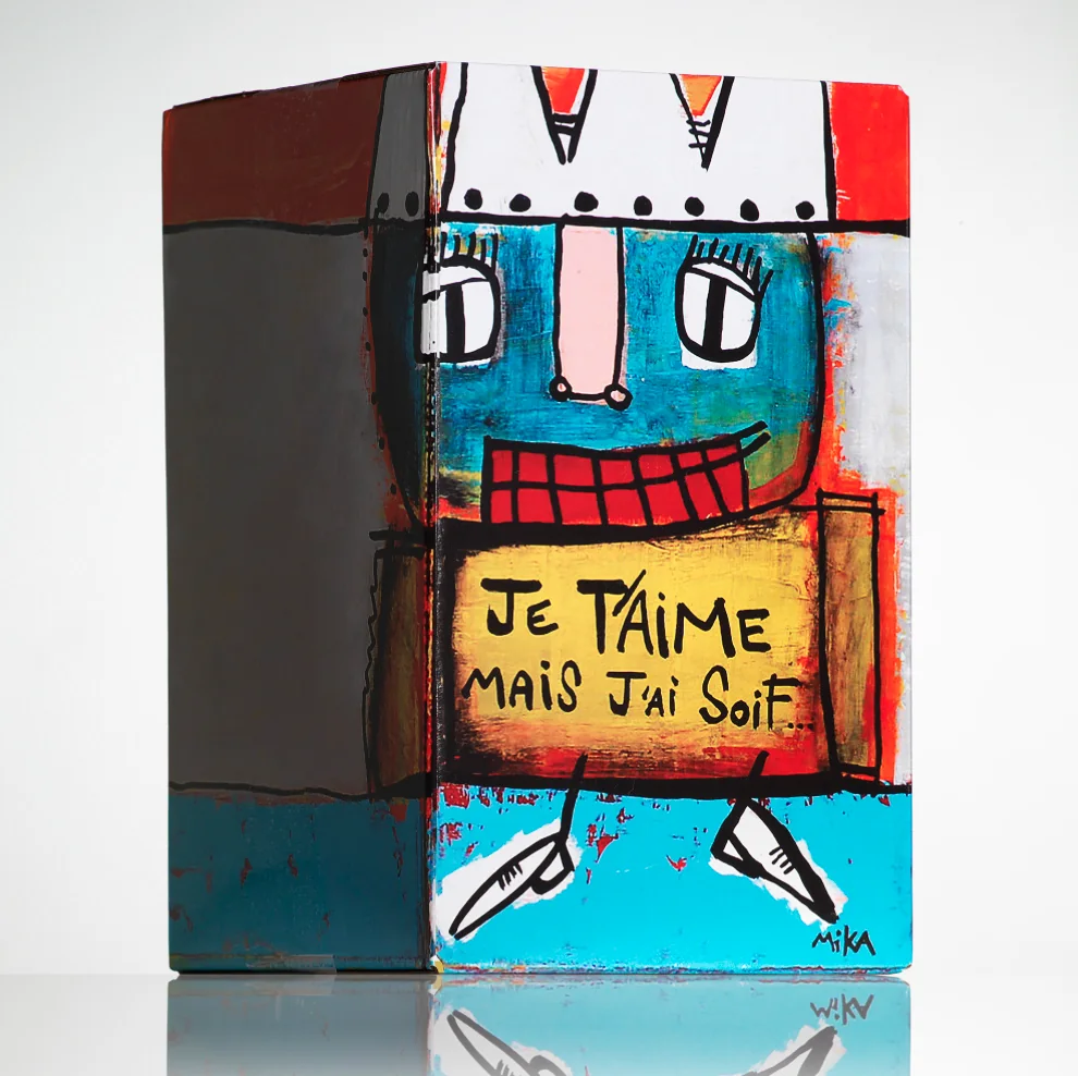 Colorful box with smiling face holding sign saying 'Je t’aime mais j’ai soif'