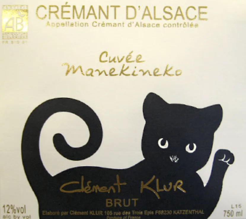 Close-up of a wine label 'Crémant d'Alsace Cuvée Manekineko' featuring black cat illustration