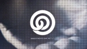The Noguchi Naohiko Sake Institute logo, a white spiral mark with the institute name, over a blue-gray halftone image of Noguchi Naohiko